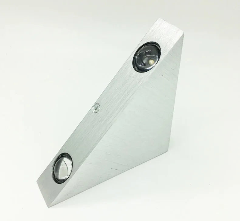 Set of three white LED wall lights with dual heads mounted on a wall showing warm white light