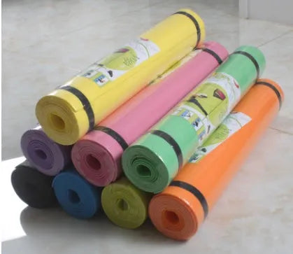 Red EVA fitness yoga mat with rolled edge showing thickness, alongside a blue mat and OPP storage bag.
