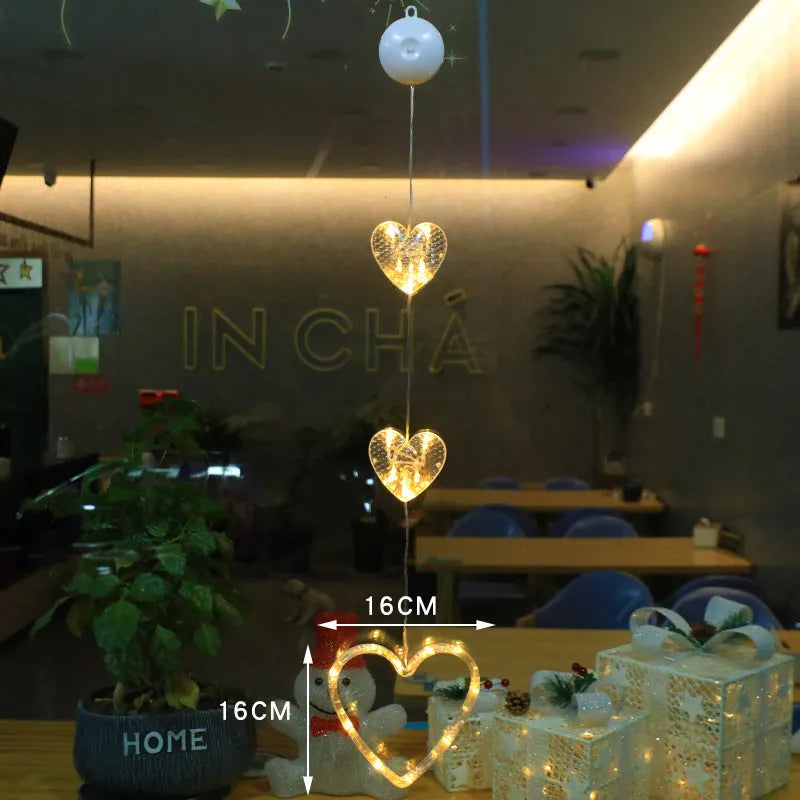 Three Christmas LED light ornaments with suction cups hanging on window