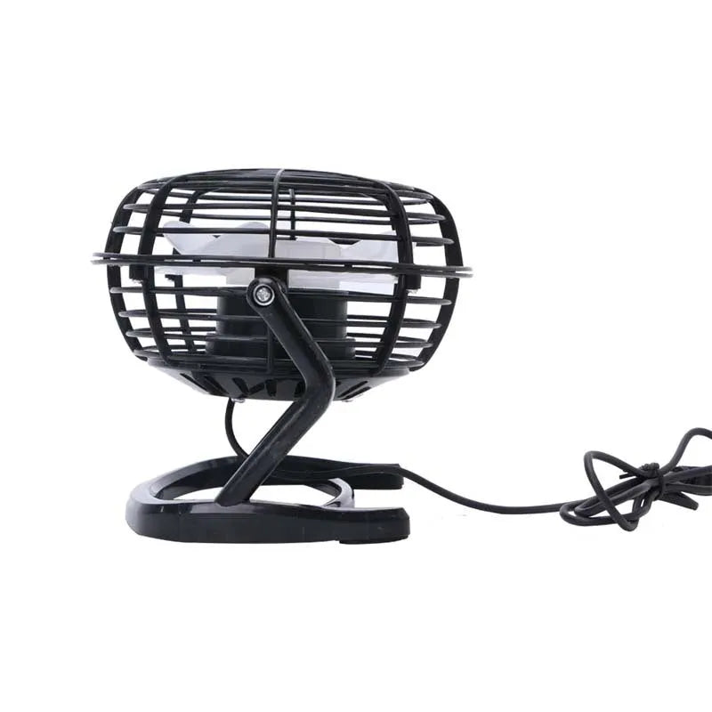 Mini black USB desk fan with adjustable tilt angle on a wooden desk next to a laptop.