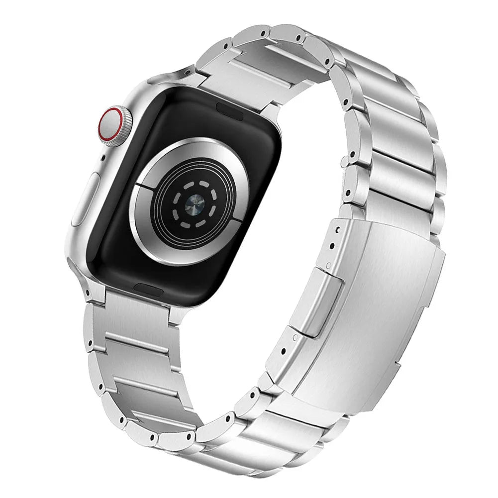 Black titanium metal Apple Watch band with a folding buckle on a table