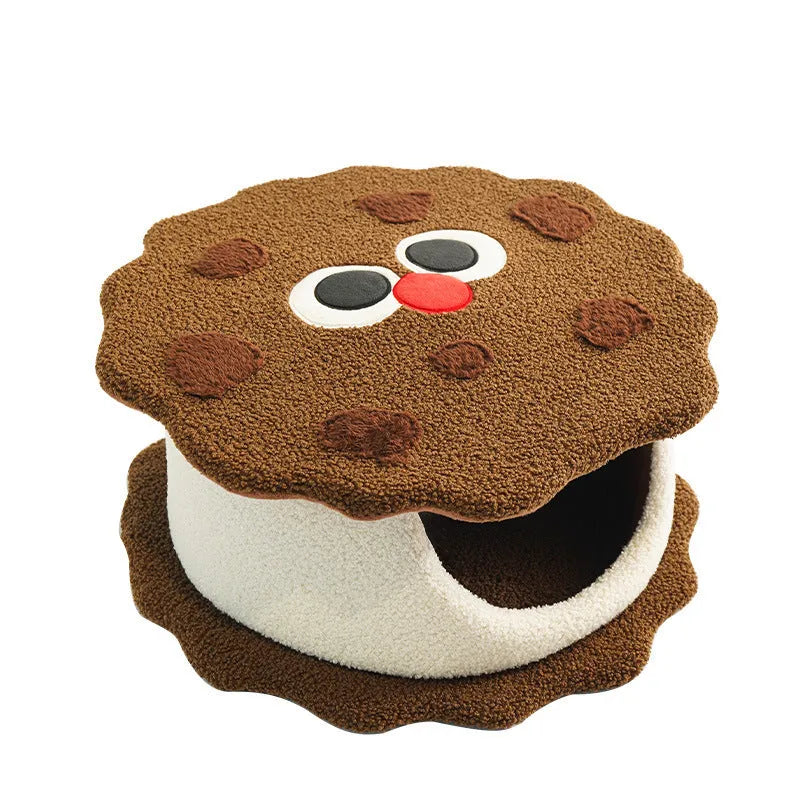 Khaki coloured enclosed cat nest shaped like a sandwich cookie with a circular entry hole.