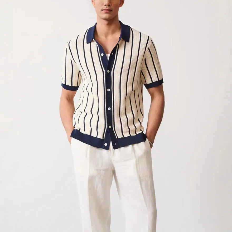 Man wearing a white asymmetric lapel knitted polo shirt with a striped pattern.