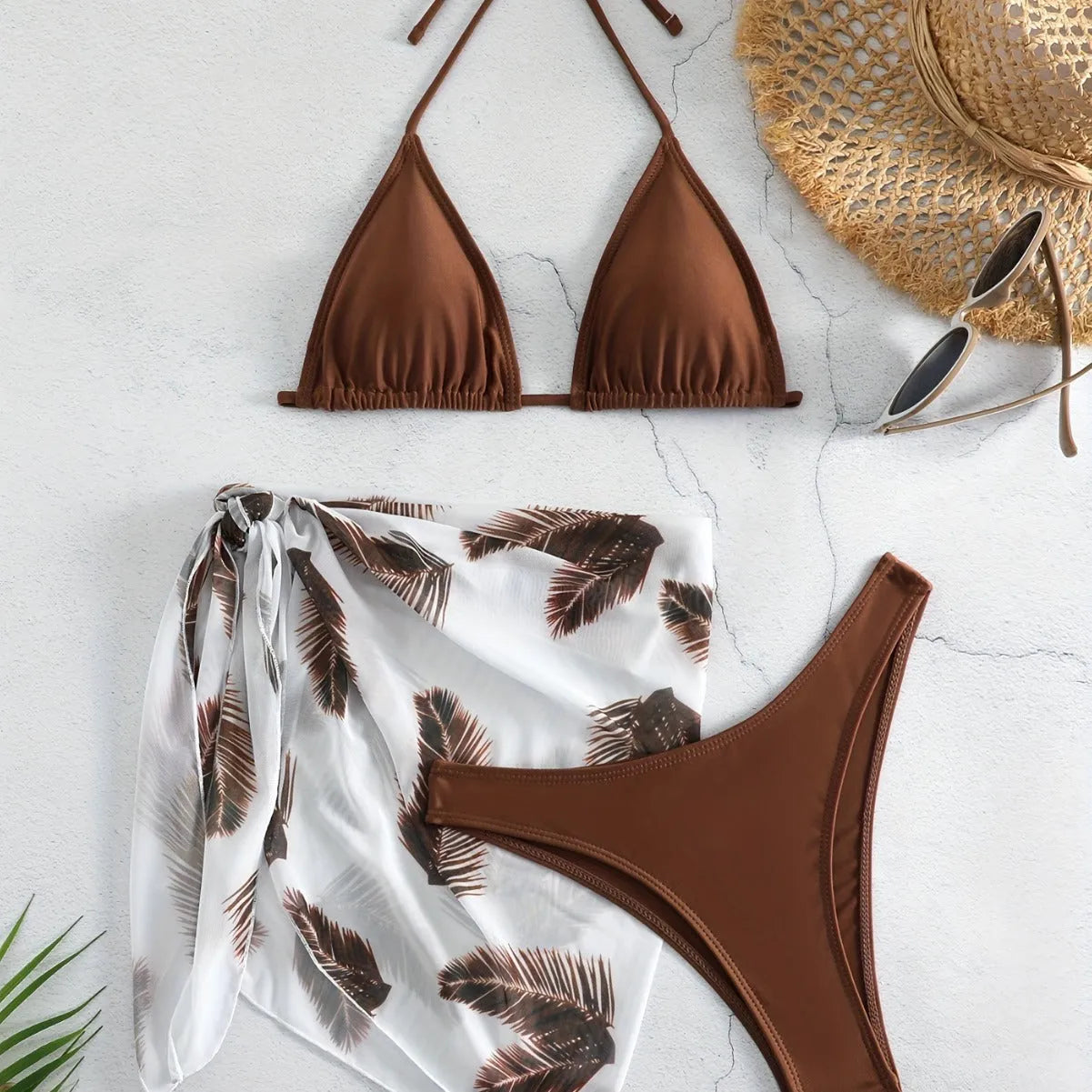 Women's orange three-piece bikini swimsuit set with a matching gauze skirt on a mannequin