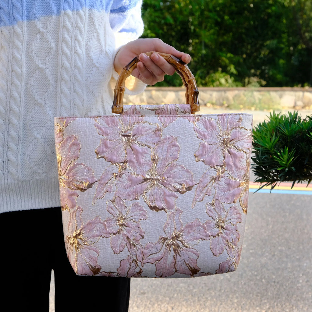 Light blue canvas shoulder bag with bronzing flower print, square shape, and two adjustable connector straps