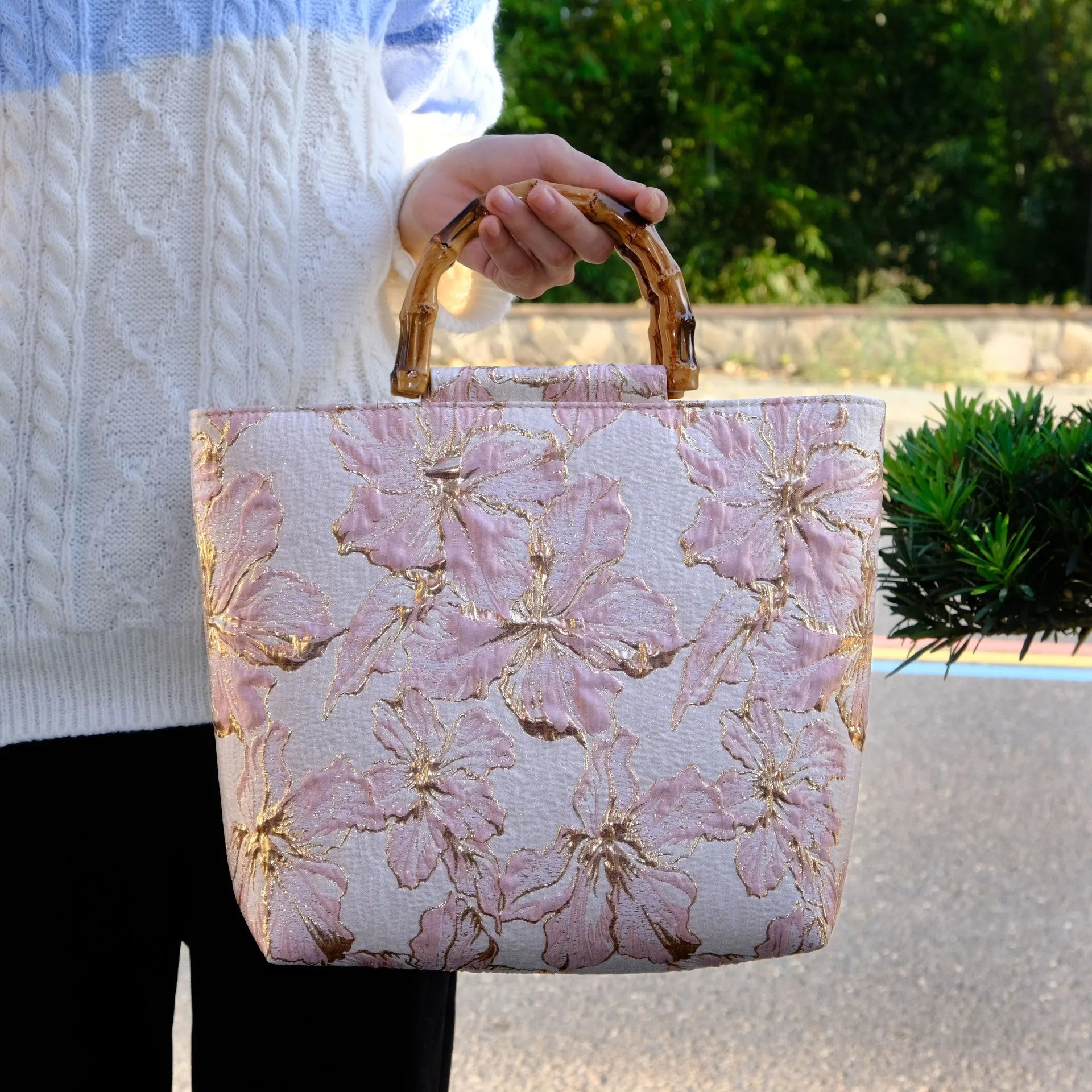 Light blue canvas shoulder bag with bronzing flower print, square shape, and two adjustable connector straps