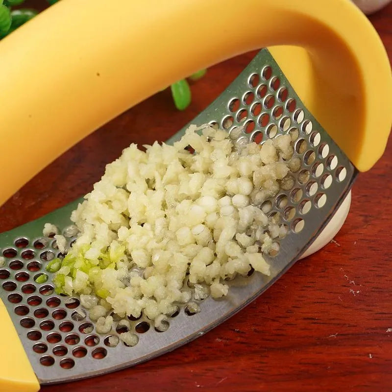 Stainless steel garlic press with non-slip handle in available colours crushing garlic