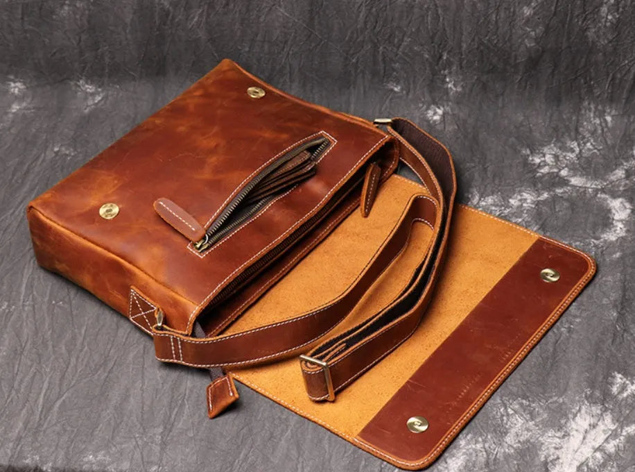Vintage brown cowhide men's messenger bag showing front flap and adjustable shoulder strap