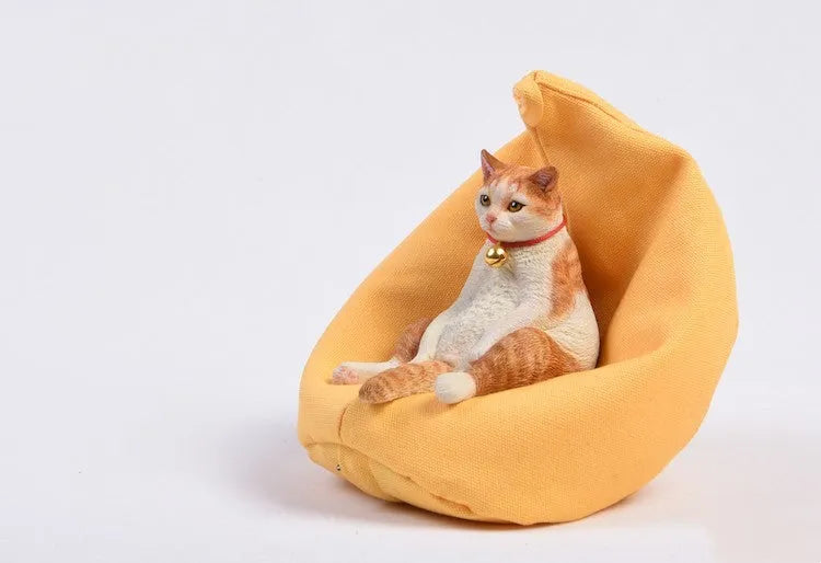 Resin lazy cat car ornament with fabric sofa, approximately 7.5cm high.