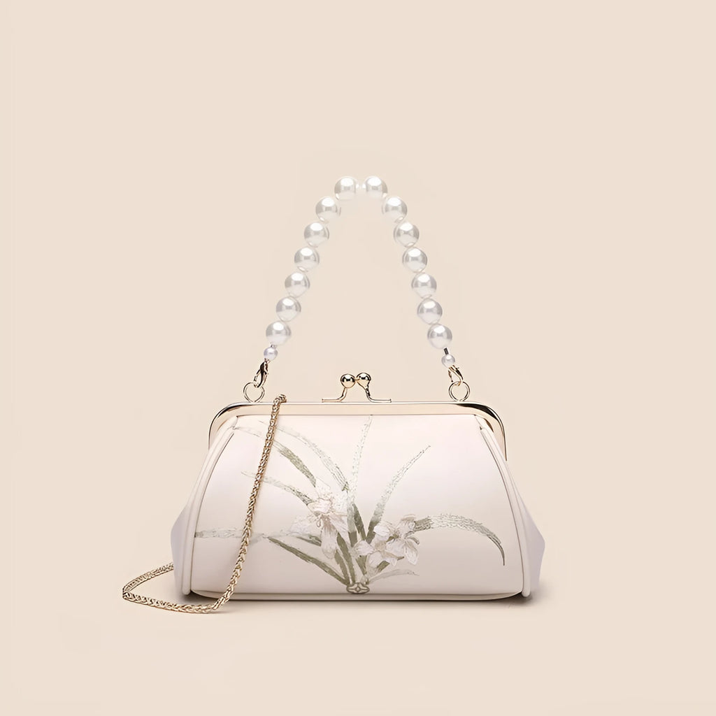 Beige women's shoulder bag with embroidered detailing and a soft, shell-shaped design.