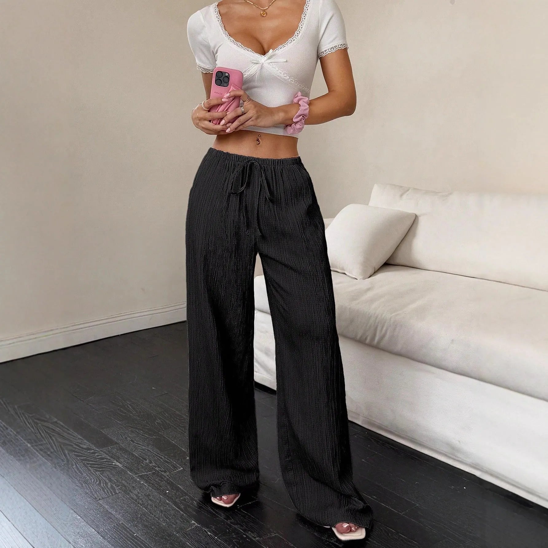 Black wide-leg women's trousers with a lace-up detail on the mid-rise waistband.