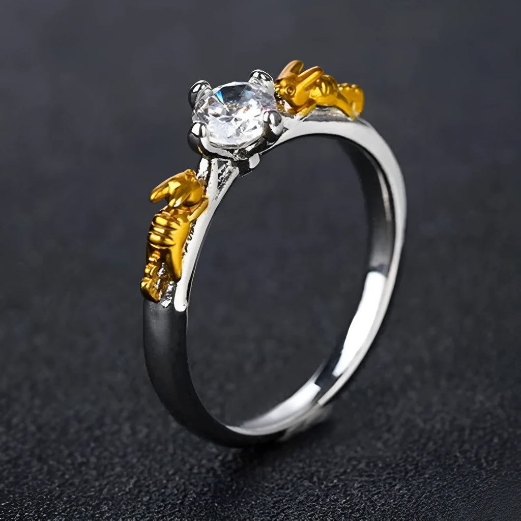 Copper crown-shaped crystal ring in a black gold tone on a neutral background.