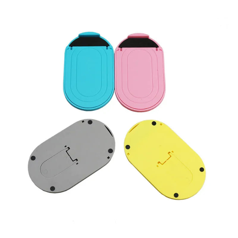 Adjustable plastic mobile phone stand in one of six colour options: black, blue, grey, pink, white, or yellow.