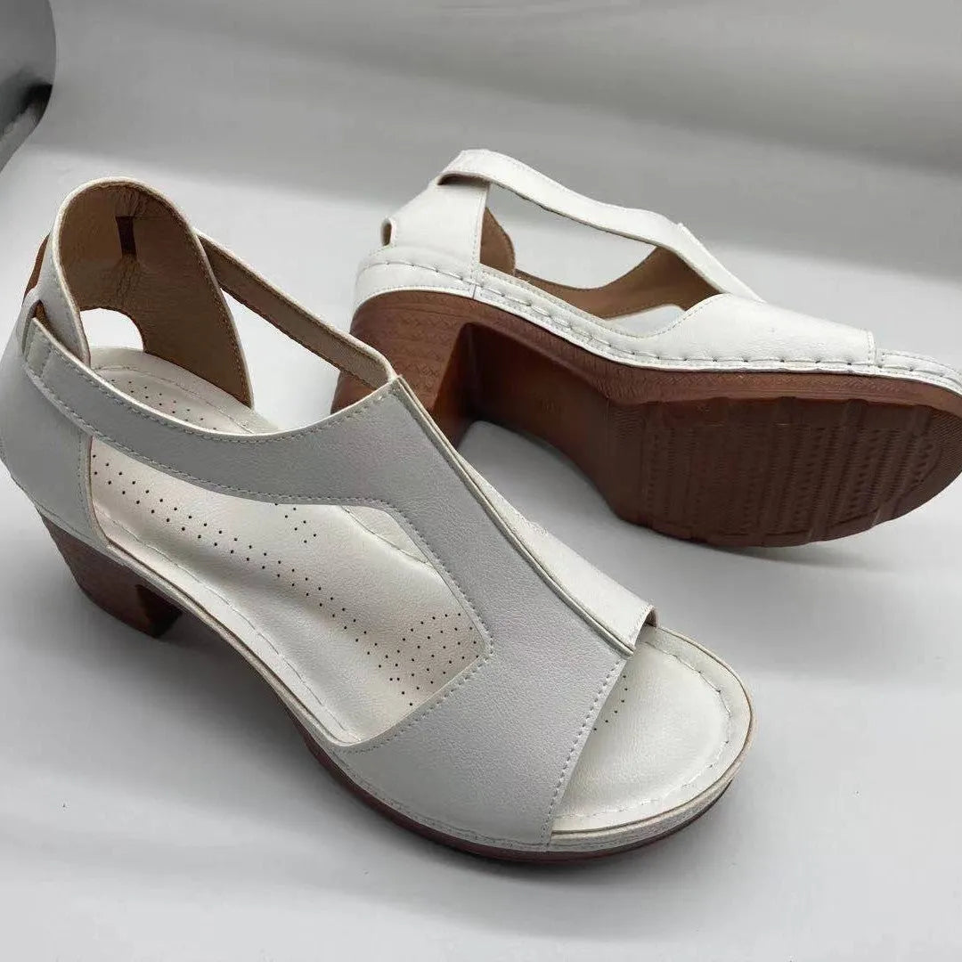 Womens beige Roman style wedge sandals with open peep toe and silver buckle strap on a low heel.