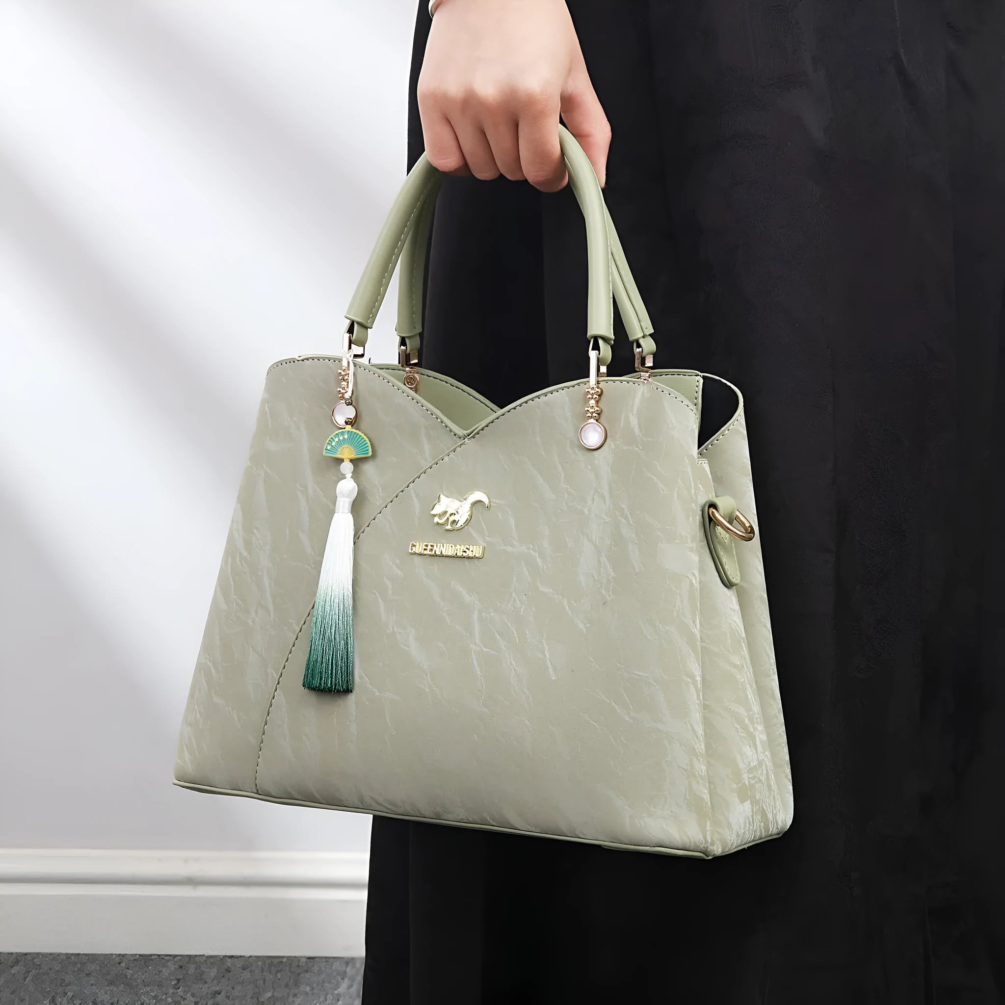 Women's black PU leather messenger bag with sewing thread detail and adjustable shoulder strap