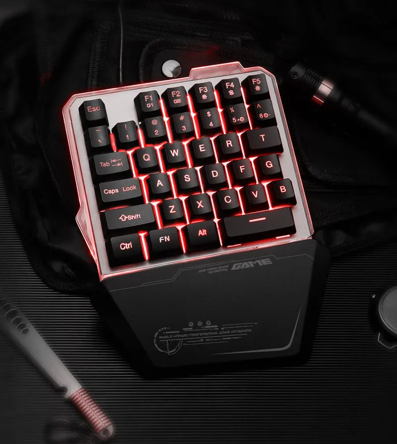 Black robotic one-handed mechanical keyboard with RGB backlit keys on a desk.