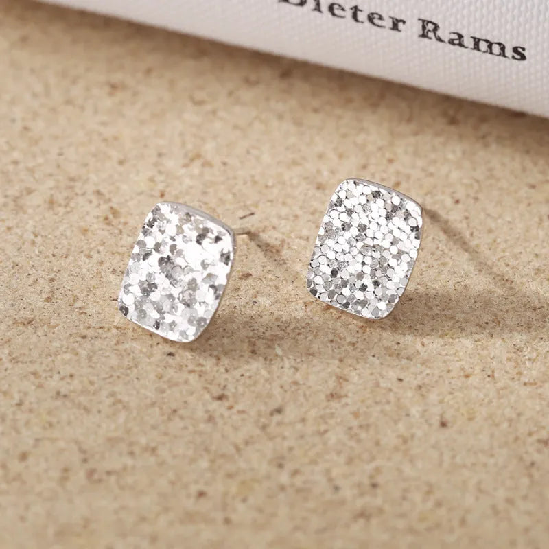 Pair of crushed ice square 925 silver stud earrings with white gold colour finish and geometric carved surface
