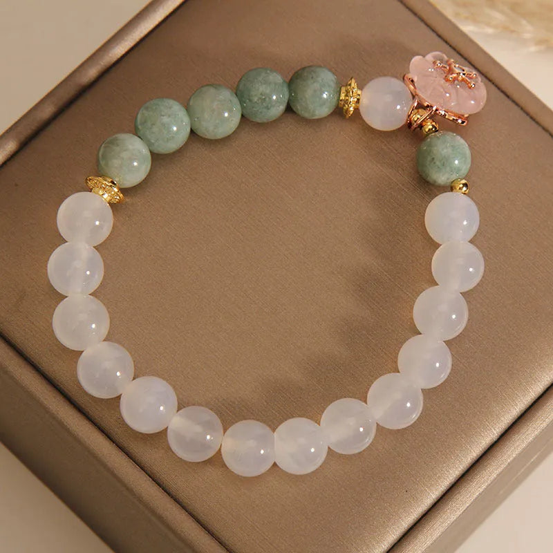 Jade floral bracelet with white agate jadeite stone and pink flower details on wrist
