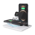 Black desktop wireless charging station with phone on pad, showing watch and headphone charging ports.
