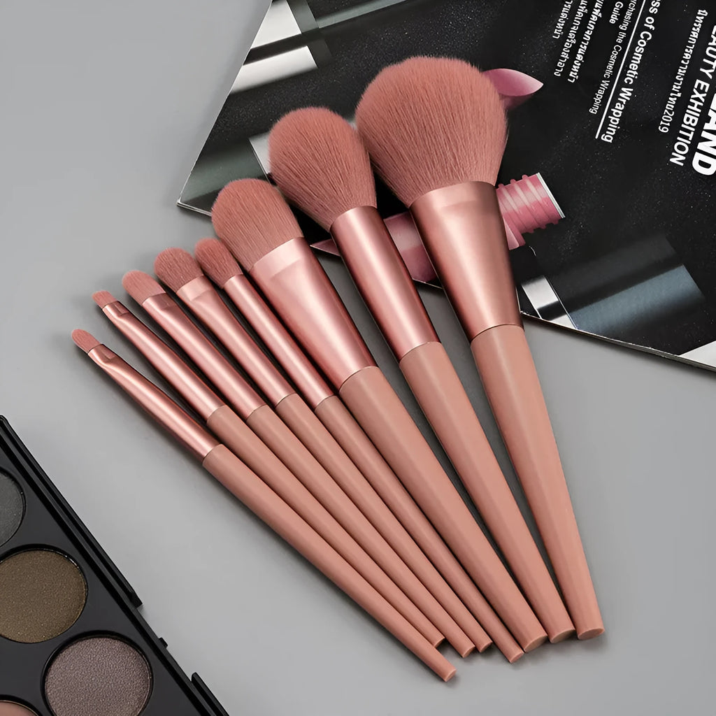 8-piece pink makeup brush set with man-made fibre bristles and plastic handles on white background