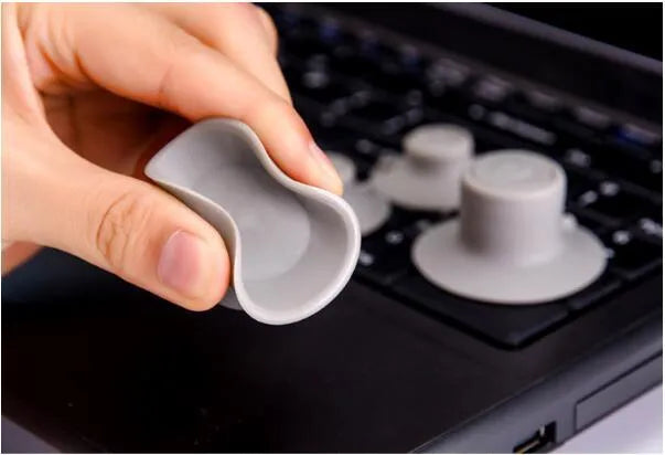 Set of four grey plastic laptop cooling pads, two large and two small, on a desk.