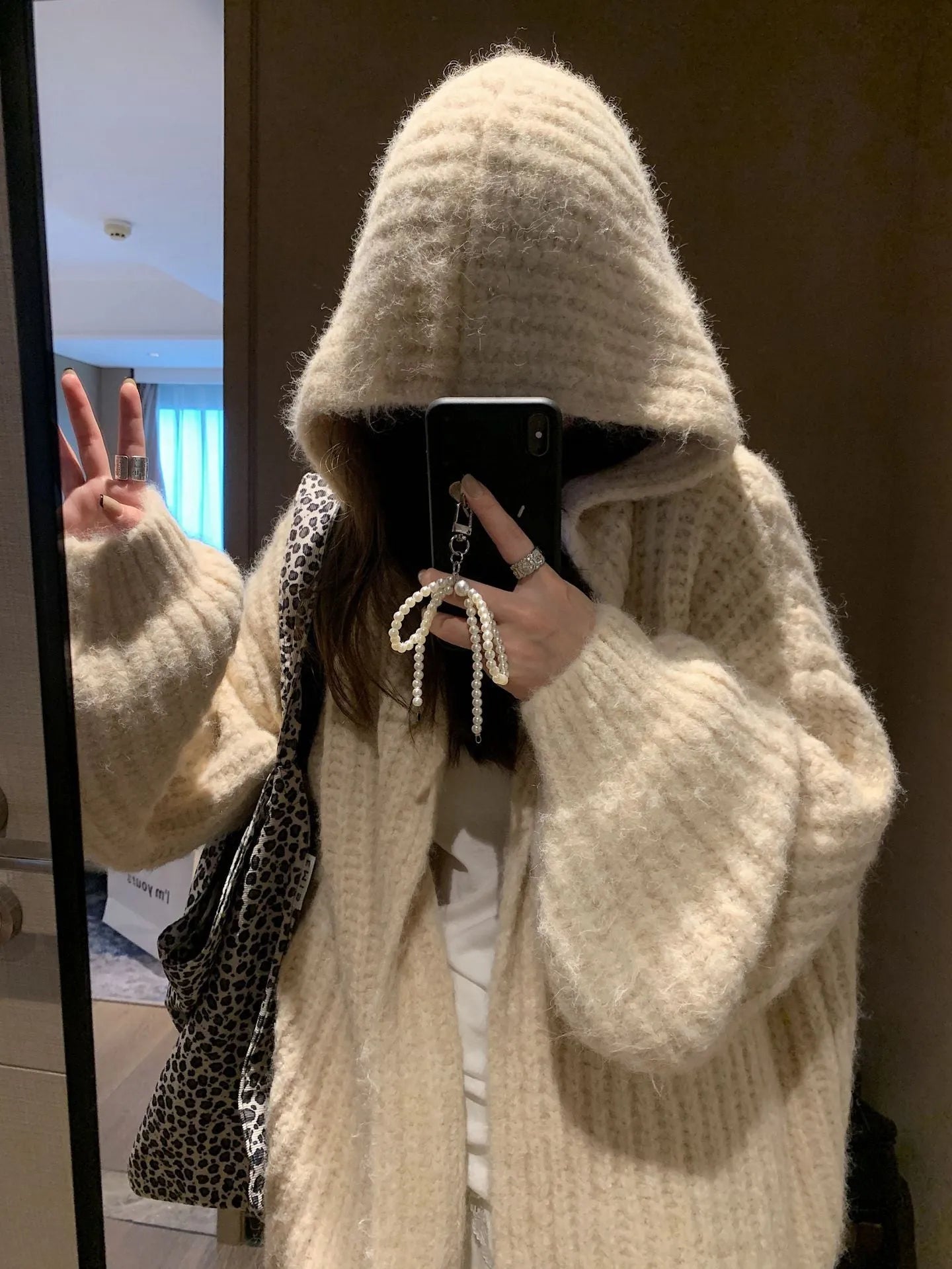 Brown women's hooded sweater cardigan with thick knit and loose fit on a hanger.