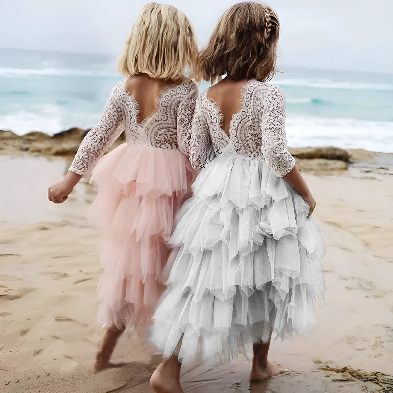 White long-sleeved lace princess dress for girls with an irregular hemline, shown on a hanger.