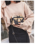 Black hard shell women's shoulder bag with a flap and crossbody strap