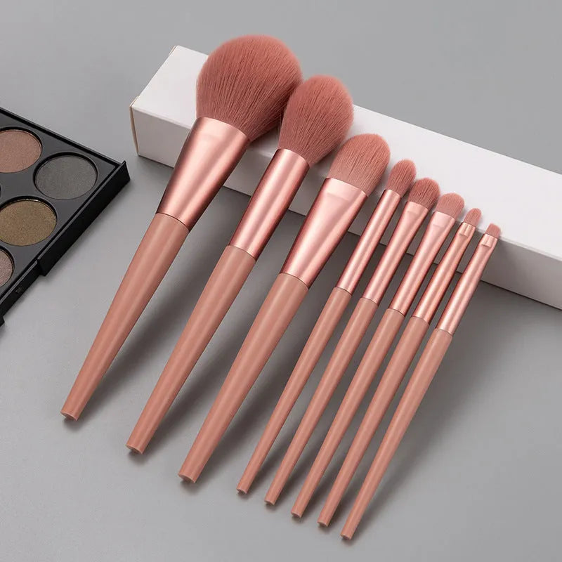 8-piece pink makeup brush set with man-made fibre bristles and plastic handles on white background