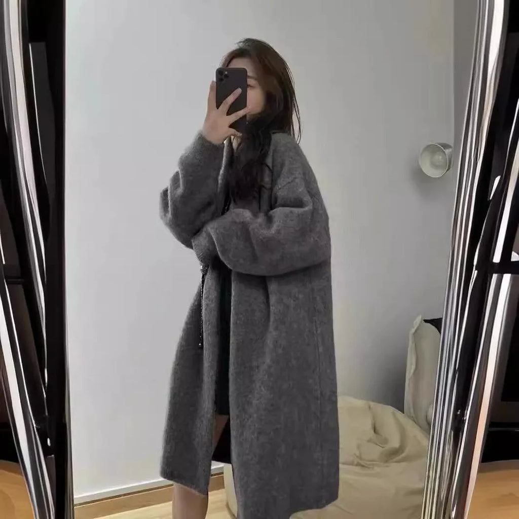 Women's loose fit grey knitted V-neck cardigan coat with long sleeves, shown mid-length.