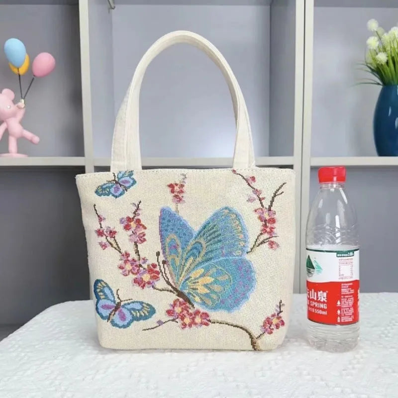 Double-sided gold wire embroidered canvas handheld bag in a floral design with polyester lining.