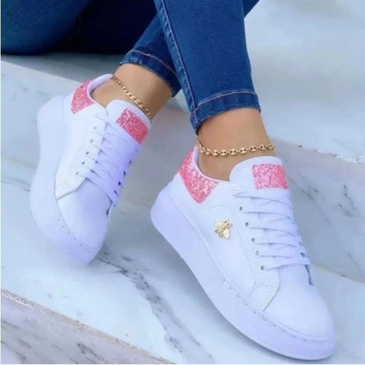 White low-top platform sneakers with lace-up closure and rubber sole on a light background