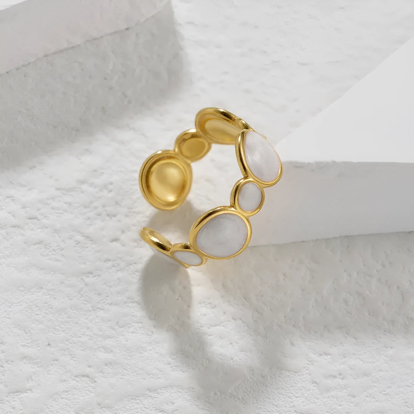 Silver geometric ring with an adjustable opening on a plain background