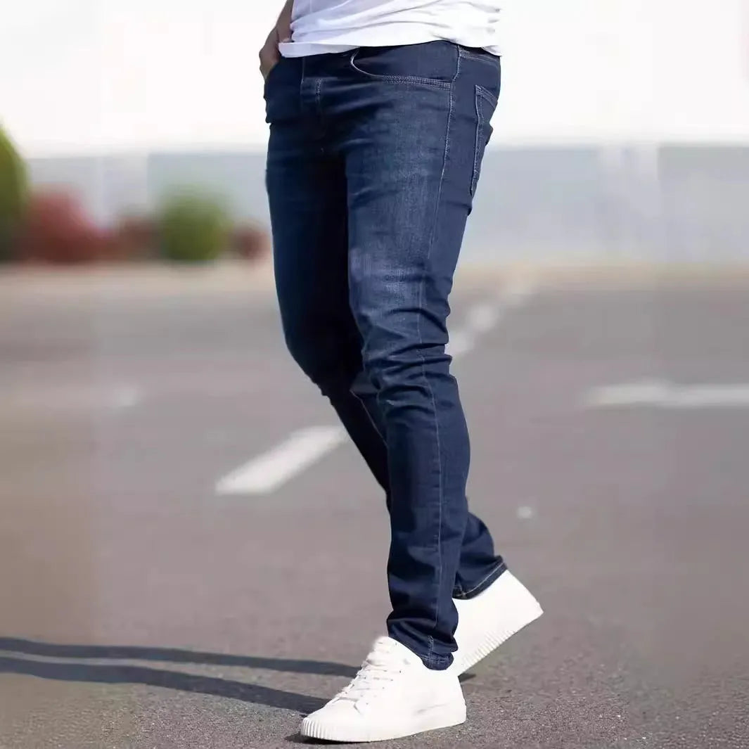 Man wearing dark blue slim-fit skinny jeans with a mid waist and zip fly.