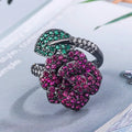 Geometric black gold plated ring with red simulated corundum stone in a floral setting.