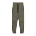 Man wearing dark grey loose-fit ankle-tied fitness trousers made of quick-drying polyester.
