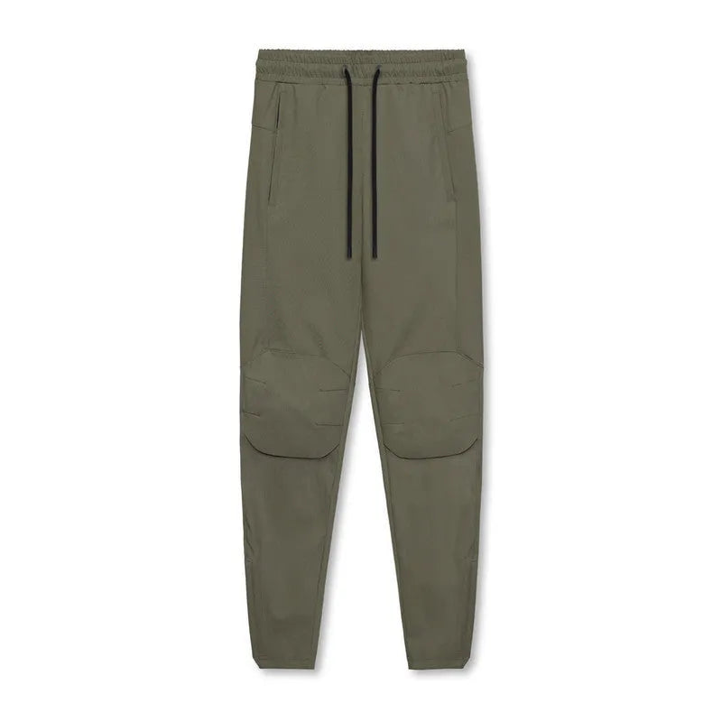 Man wearing dark grey loose-fit ankle-tied fitness trousers made of quick-drying polyester.