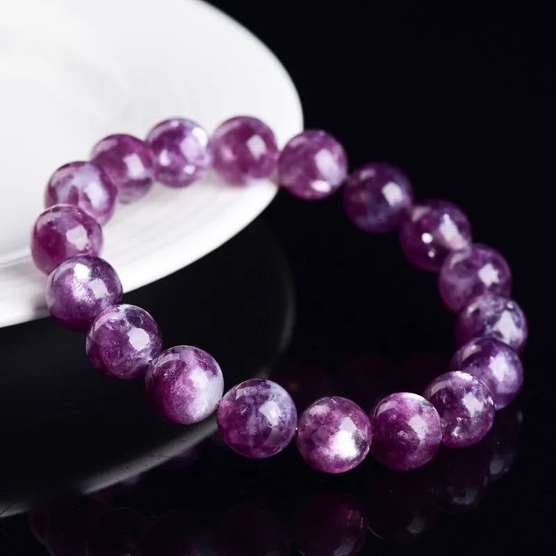 Polished purple crystal bracelet with geometric beads on a white background.