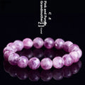 Polished purple crystal bracelet with geometric beads on a white background.