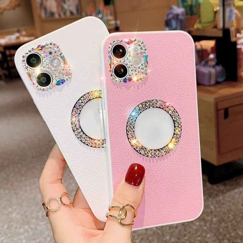 Luxury rhinestone TPU back cover phone case for iPhone in pink, purple, and white on a surface