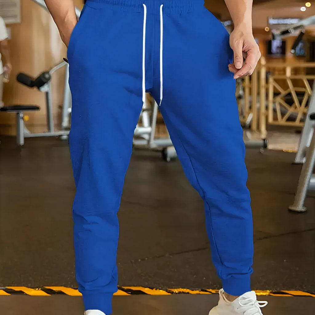 Man wearing grey loose-fit linen-style leisure trousers with an elastic drawstring waistband.