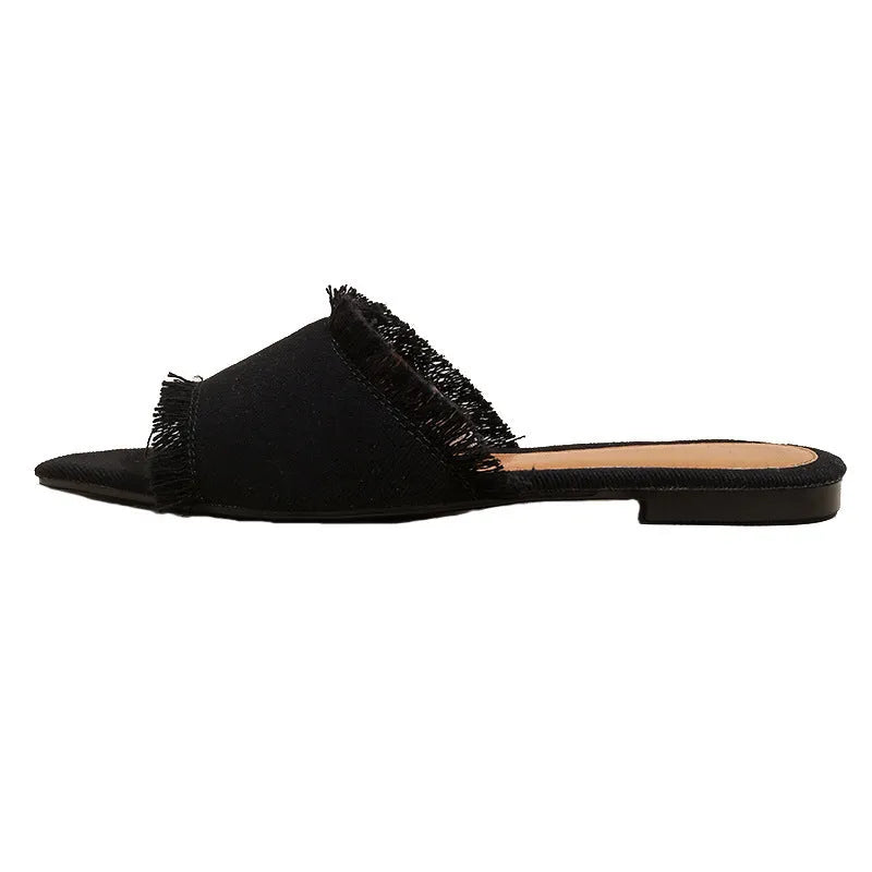 Women's denim slippers with tassel detail and leather lining in various colours on a flat PVC sole.