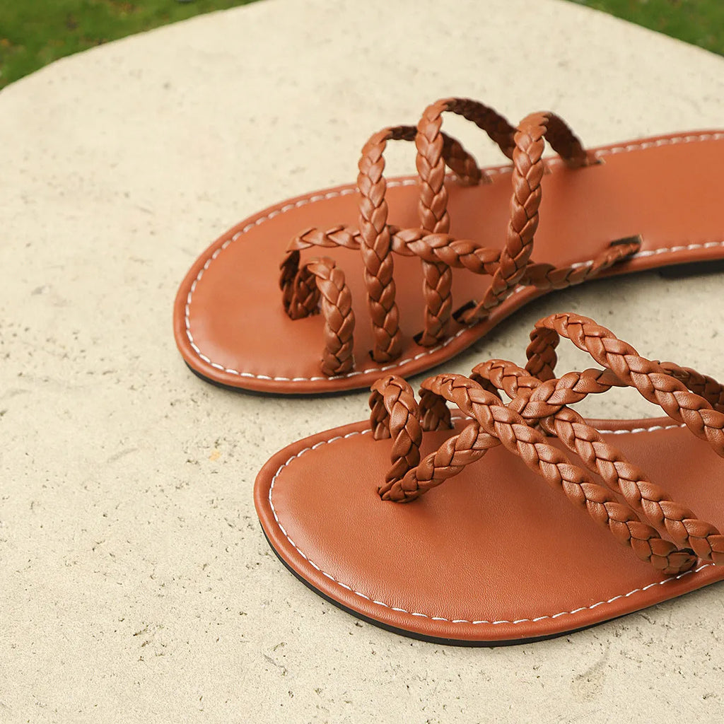 Women's white clip-toe woven flat sandals on a plain background