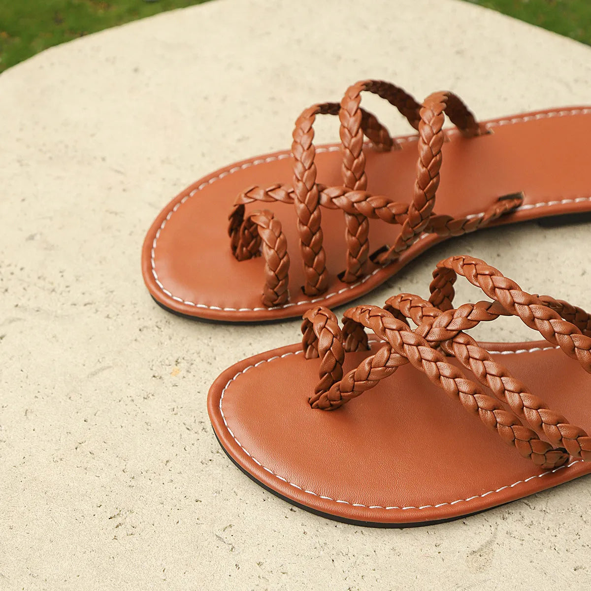 Women's white clip-toe woven flat sandals on a plain background