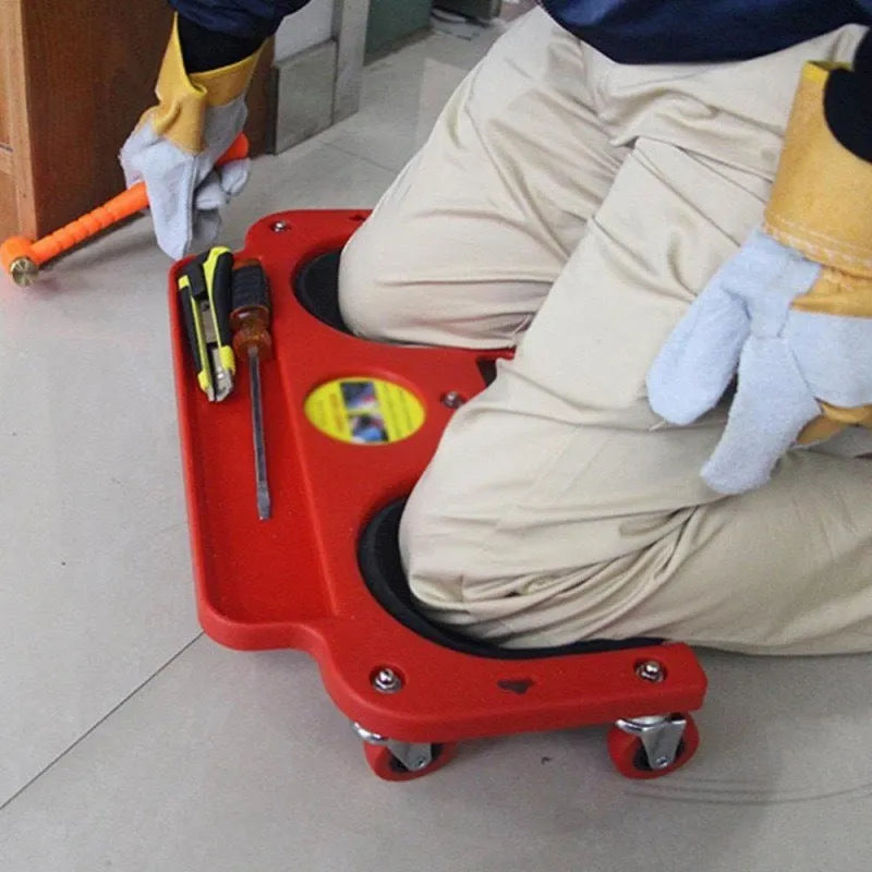 Blue car repair knee board with universal wheels and built-in knee pad on concrete garage floor