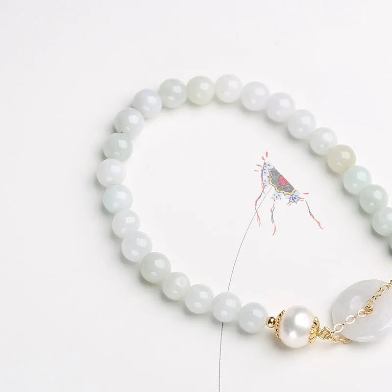 Natural jade bracelet with geometric shape, round pendant, and peace buckle closure on a wrist.