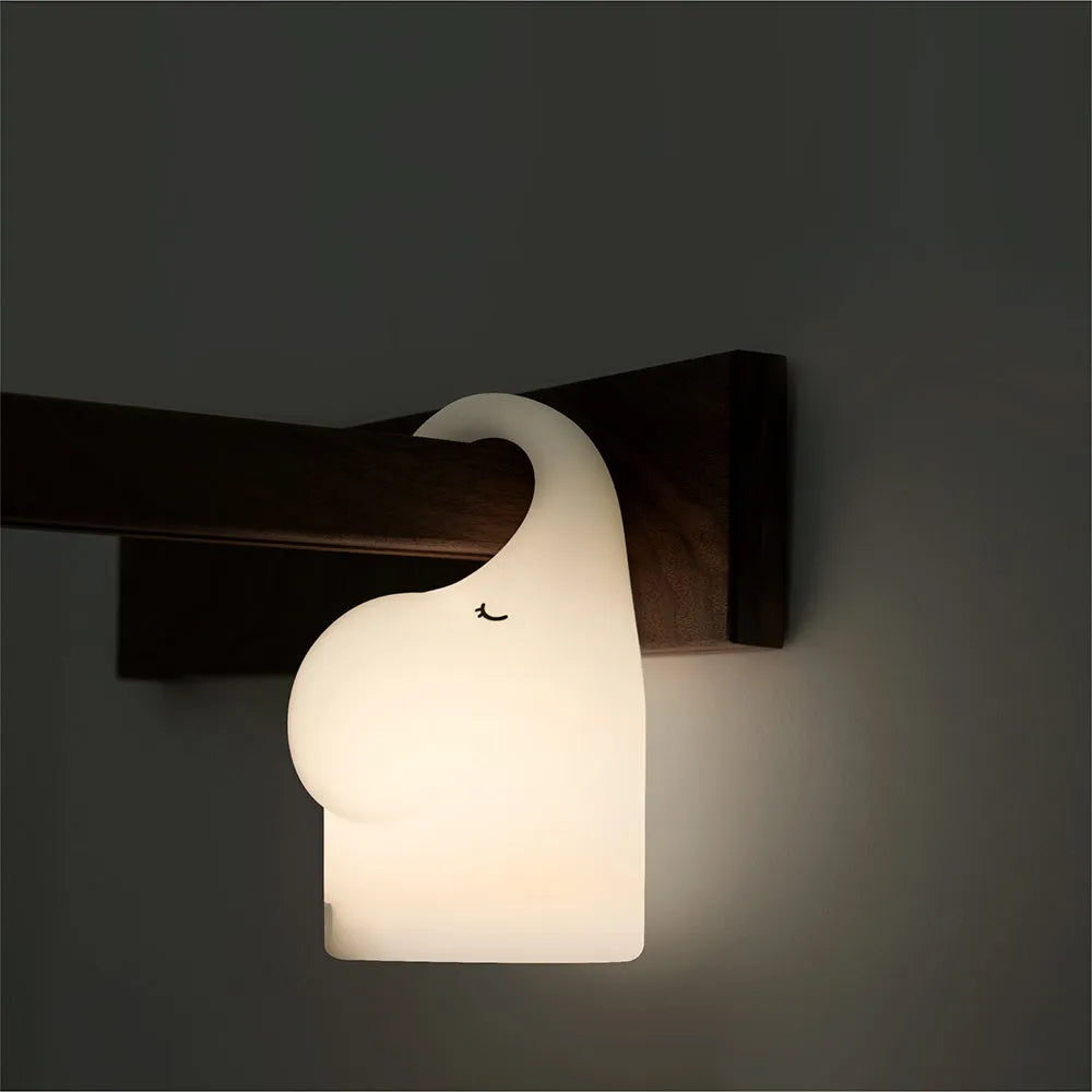 DOMI elephant-shaped silicone night light in warm white, showing its compact size.