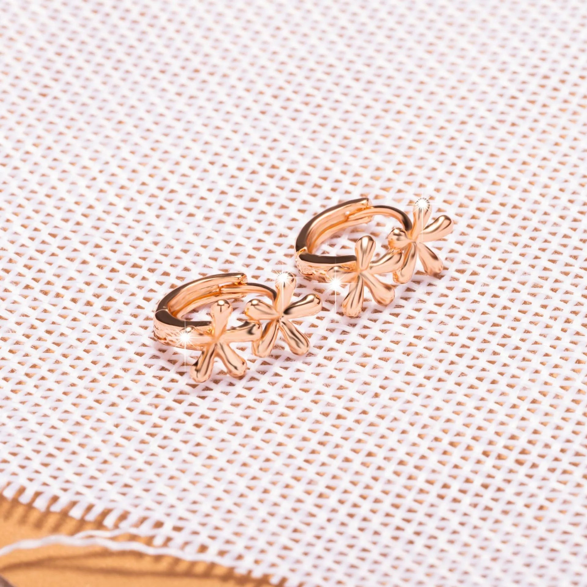A pair of rose gold coloured waterdrop and circular shaped women's earrings on a white background.