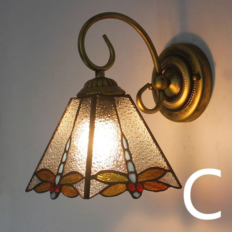 A coloured stained glass wall lamp mounted on a corridor wall, showing one of six available style designs.