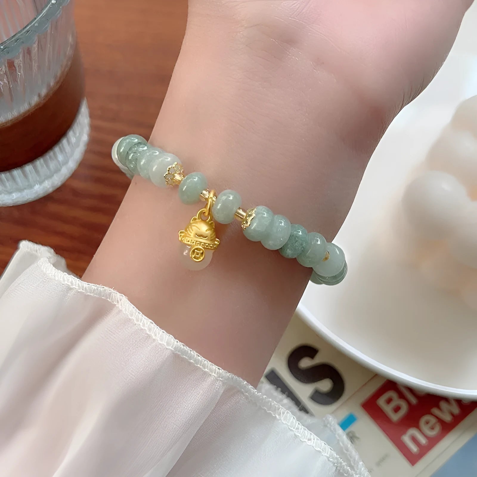 Women's strawberry quartz bracelet with a retro lucky cat charm in grey jade.